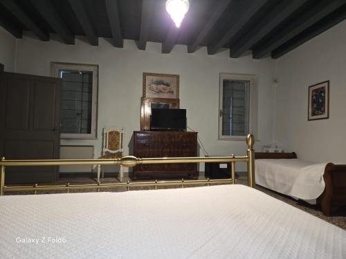 een slaapkamer met een bed en een tv in een kamer bij Villa Trigatti 