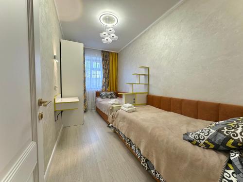 ein kleines Zimmer mit zwei Betten und einem Fenster in der Unterkunft Karakol 'Ethno' Apartment in Karakol