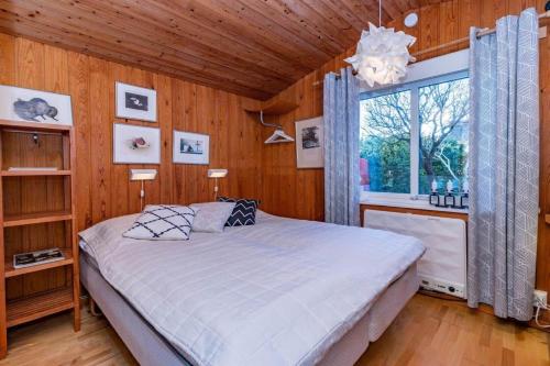 a bedroom with a bed in a room with wooden walls at BLE885-Ramdala-Ormen-langes-vaeg-10 in Ramdala