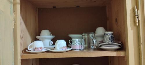 een plank met kopjes en borden erop bij Appartement Naim in Tozeur