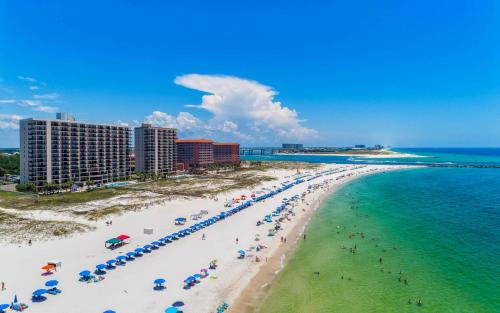 a beach with umbrellas and people on the sand and the ocean at Phoenix East II 2032 in Orange Beach