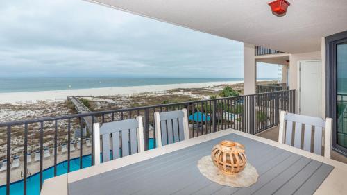 a table on a balcony with a view of the beach at Phoenix East II 2033 in Orange Beach