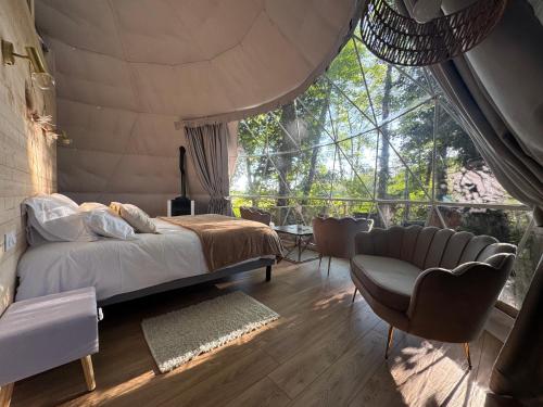 a bedroom with a bed and a large window at Bulle au Fil de l'eau in Romilly-sur-Andelle