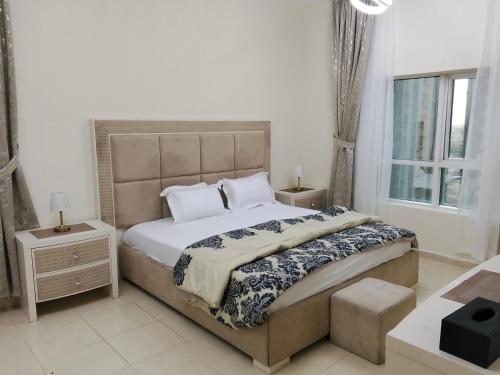 a bedroom with a large bed and a window at Orient Tower in Ajman 
