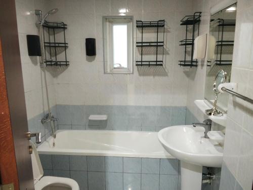 a bathroom with a tub and a sink and a toilet at Orient Tower in Ajman 