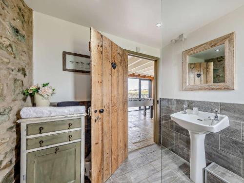 a bathroom with a sink and a mirror at 4 Bed in Llanfechell 90258 in Llanfechell