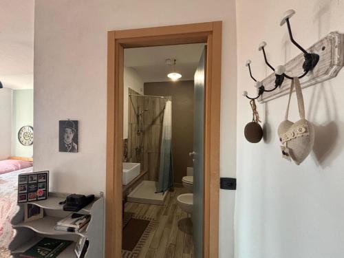 a bathroom with a door open to a bathroom with a toilet at Cascina Teresina Monferrato Piscina in Cortazzone