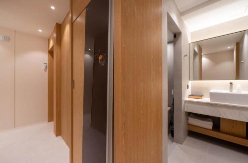 a bathroom with a sink and a mirror at Daisy hotel in Tongyeong