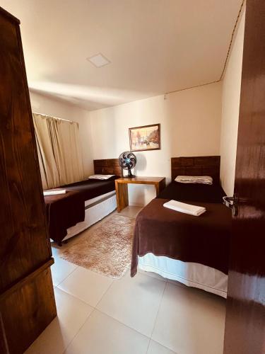a hotel room with two beds and a couch at Condomínio Sonhos Da Serra in Bananeiras