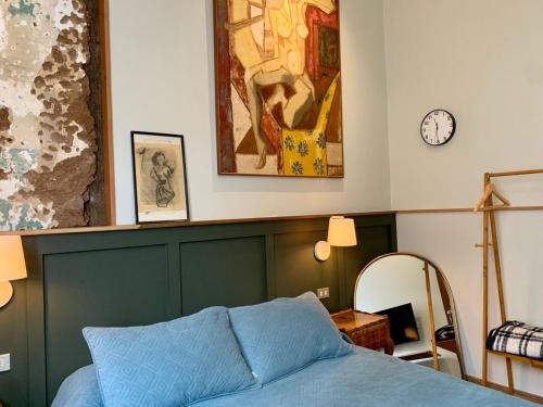 a bedroom with a bed and a clock on the wall at Hostal Dinamarca in Valparaíso
