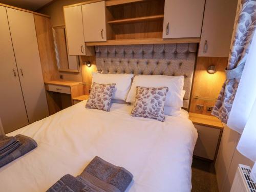 a bedroom with a large white bed with two pillows at Paws By The Sea in Norwich