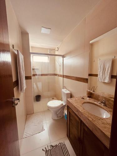 a bathroom with a toilet and a sink and a shower at Condomínio Sonhos Da Serra in Bananeiras