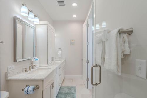 a white bathroom with a shower and a sink at Punta Rassa Pointe by Sun Palace Vacations in Fort Myers