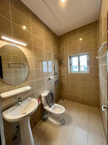 un bagno con un water, un lavandino e uno specchio di Hôtels Résidences Easy a Cotonou
