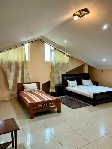 una camera da letto con un letto, un divano e un tavolo di Hôtels Résidences Easy a Cotonou