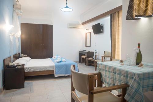 una camera d'albergo con un letto e due tavoli di Antonios Hotel a Faliraki