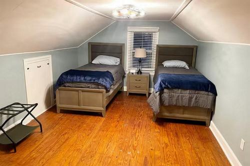 a bedroom with two beds and a wooden floor at Bourbon Belle of Bardstown in Bardstown
