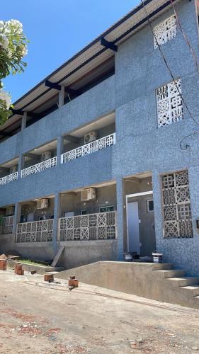 a blue brick building with a ramp in front of it at Flats das Marias in Jequia da Praia
