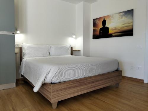 ein Schlafzimmer mit einem Bett mit einem Bild an der Wand in der Unterkunft My way in Sassoferrato