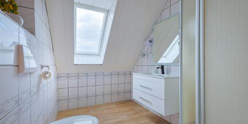 een witte badkamer met een wastafel en een spiegel bij DUA Hotel in Sarstedt