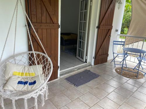 een veranda met een schommel, een stoel en een tafel bij Appartement l'écrin in Saint-Claude