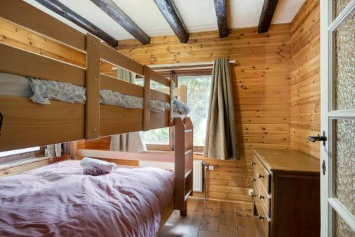 a bedroom with a bunk bed in a log cabin at Le Chalet Rustique in Spa