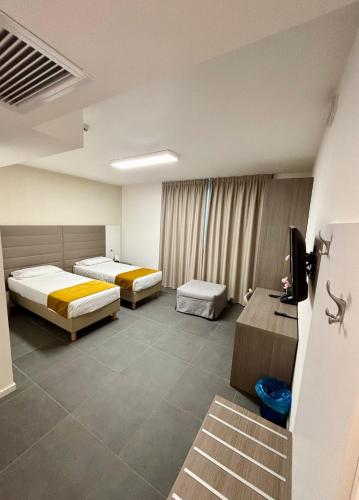 a hotel room with two beds and a television at Blu Hotel in Buccinasco