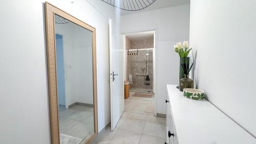 a bathroom with a mirror and a vase of flowers on a counter at Studio récent avec terrasse Clim Airbus Aéroport in Colomiers