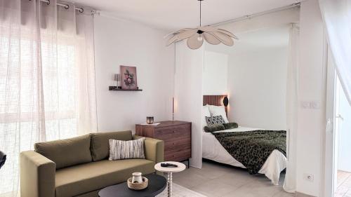 a living room with a couch and a bed at Studio récent avec terrasse Clim Airbus Aéroport in Colomiers