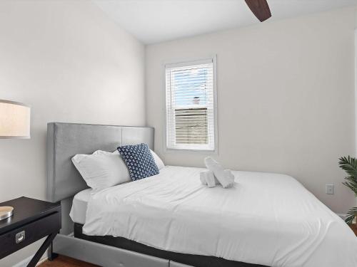 a white bedroom with a bed with a teddy bear on it at NoMA 3BR Townhome - UnionMarket H St Streetcar in Washington, D.C.