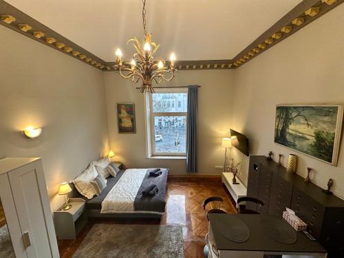 una camera da letto con un letto e un lampadario di Elegantes Innenstadt Apartment a Brema