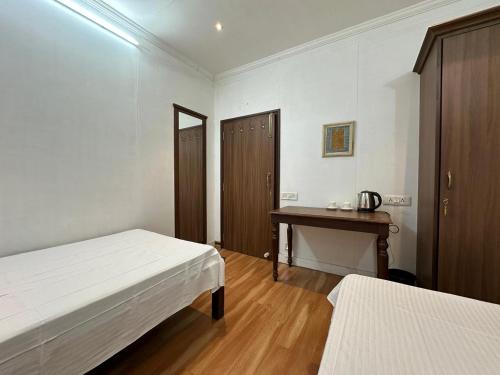 a white room with two beds and a desk at Junput Guest House in Bichania