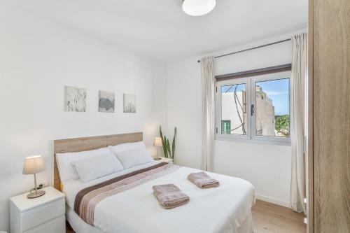 a white bedroom with a large bed and a window at Villa Star in Agaete