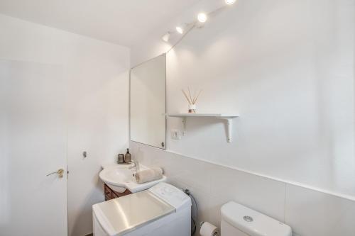 a white bathroom with a sink and a toilet at Villa Star in Agaete