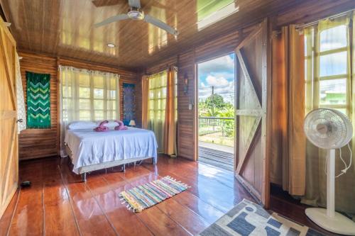 een slaapkamer met een bed, een raam en een ventilator bij Cabañas Retiro Del Rio in Guayabal