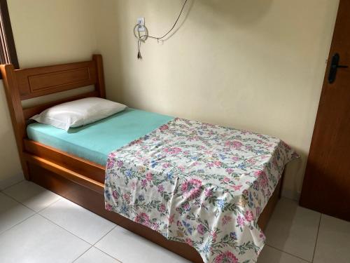 a small bedroom with a bed with a floral bedspread at Refúgio Familiar Kingdom in Tramandaí