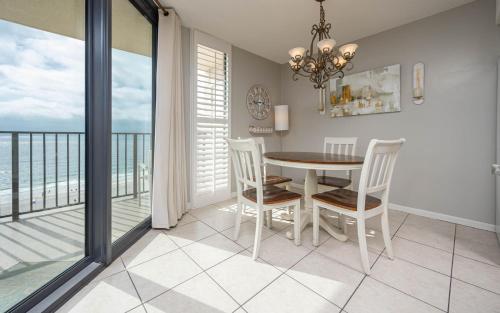 a dining room with a table and chairs and a balcony at Phoenix East II 2092 in Orange Beach