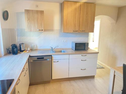 a kitchen with a sink and a microwave at Gemütliche Wohnung mit Berg- und Waldblick in Balingen