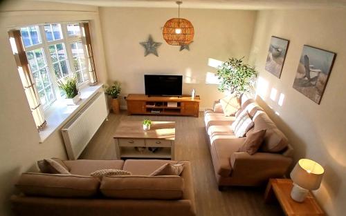 a living room with two couches and a tv at Stylish Seaside Cottage - 3 minute walk to beach with parking in Skegness