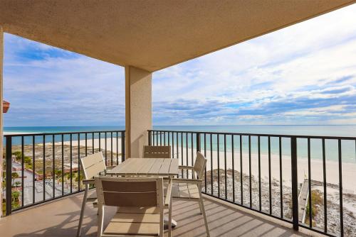 a balcony with a table and chairs and the beach at Phoenix East II 2092 in Orange Beach