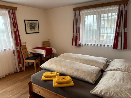 a bedroom with two beds with yellow towels on them at Ferienwohnung Mayrhofer in Leogang