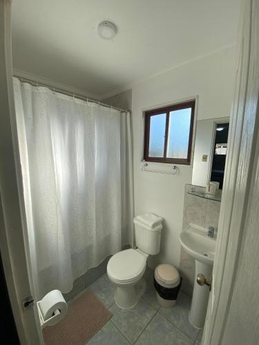 ein weißes Badezimmer mit Toilette und Waschbecken in der Unterkunft Rancho Carmelitas Cabañas Familiares en Pullally, comuna Papudo in Quinquimo