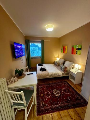 una camera da letto con un letto, un tavolo e una scrivania di Stilvolles Landhausstil Apartment - Zentral a Brema