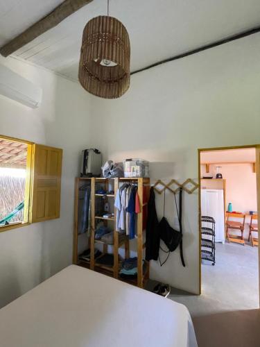 a bedroom with a bed and a room with a mirror at CARAÍVA House in Caraíva