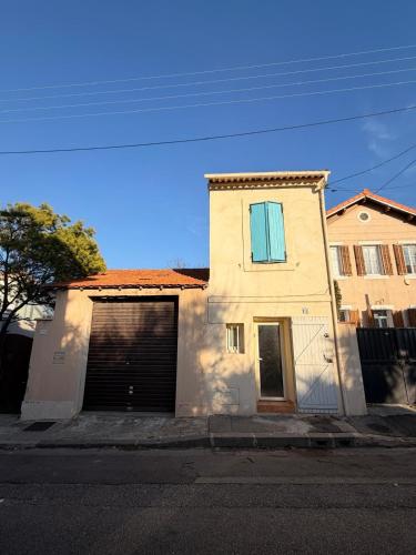een wit huis met een garage in een straat bij Chez Theo in Marseille