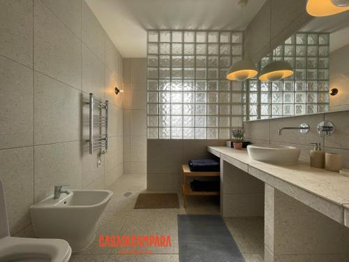 a bathroom with two sinks and a tub and a toilet at Casa di Campara Almada Villa in FAO