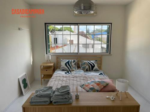 a bedroom with a bed and a window and a table at Casa di Campara Almada Villa in FAO