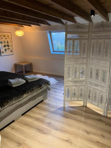 een kamer met een bed en een grote glazen deur bij vakantiewoning Het Boomkwekerijhuis in Zonnebeke