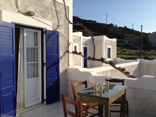 a table and chairs on a balcony with blue doors at Paradise Apartments Studios in Mylopotas