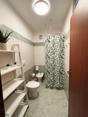 a bathroom with a toilet and a shower curtain at Bellalisa Tuscany Appartement in Sarteano